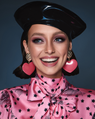 a beautiful wooman person smiling with pink lipstick and large earrings wow